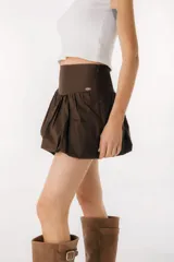 Minifalda negra con volados y detalle de etiqueta con logo en el lateral.