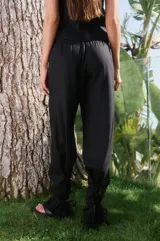 Pantalón negro de lino y rayón, tiro alto, corte suelto, elástico en la cintura trasera y lazos ajustables en los tobillos.