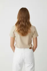 Remera de algodón color beige, manga corta y cuello redondo, con estampado frontal de una flor azul y texto en foil dorado que dice "You are Unique".