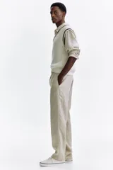 Pantalón de lino liviano para hombre, de corte regular fit y color beige. Presenta cintura elástica con cordón de ajuste oculto, bolsillos laterales discretos y un bolsillo trasero insertado.