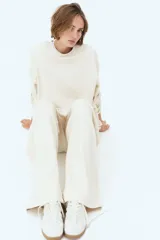 Pantalón de felpa color crema, de corte relajado con cintura elástica fruncida, bolsillos laterales discretos y piernas rectas.