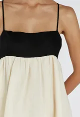 Vestido largo de tirantes finos, con corpiño negro y falda blanca.