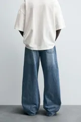 Pantalón de jean negro de corte amplio, estilo balloon fit, con cinco bolsillos y cierre frontal con botones.