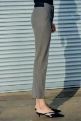 Pantalón tobillero gris con textura, de tiro medio y corte recto. Tiene cintura elástica en la parte trasera, bolsillos delanteros y falsos bolsillos traseros.