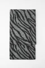 Bufanda rectangular de punto con estampado de cebra en tonos grises y negros.