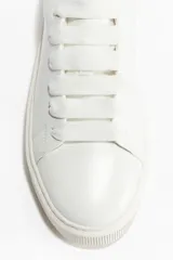 Championes blancos de cuero con cordones y suela gruesa.