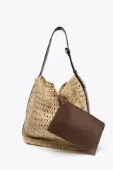 Bolso formato saca color beige, con efecto rafia en el cuerpo y asa de hombro ajustable color marrón. Incluye cartera con bolsillo extraíble y cierre mediante botón imantado.