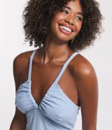 Vestido midi celeste confeccionado en jeans, con tirantes finos, escote en V, lazo en la espalda y detalle cutout.