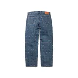 Pantalón de jean azul con diseño de cuadrícula con tachas en las costuras, corte holgado.