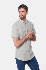 Camisa celeste de lino y algodón, de manga corta, con cuello abotonado y bolsillo en el pecho.