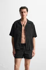 Short de baño negro de tejido técnico, con cintura elástica ajustable con cordón, bolsillos laterales y bolsillo trasero.