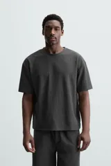 Camiseta de hombre color gris oscuro, de corte amplio, cuello redondo y manga corta.