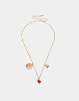 Collar corto dorado con cadena de eslabones y dijes colgantes: moneda dorada con letras NY grabadas, dos manzanas rojas esmaltadas y dije redondo dorado con corazón rosa.