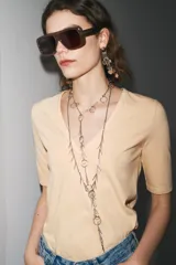 Camiseta color beige de lino con cuello en V y mangas cortas.
