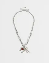 Collar dorado con cadena de eslabones grandes y dijes colgantes de corazón rojo, herradura y moño con strass.