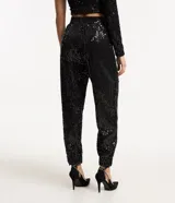 Pantalón jogger de lentejuelas negras con cintura elástica y puños ajustados.