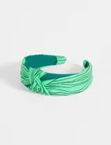 Vincha de tela verde con diseño de líneas, ideal para complementar peinados.