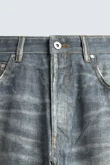 Pantalón de jean azul con efecto lavado y estampado, corte holgado y amplio en toda la pierna, tiro medio, cinco bolsillos y cierre frontal con cremallera y botón.