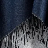 Poncho abierto color azul con borde gris y flecos negros.