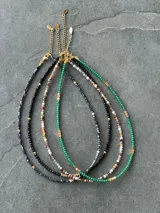 Gargantilla de cuentas verdes con detalles dorados, diseño elegante y minimalista.