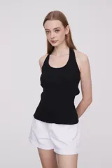 Musculosa negra de algodón con breteles finos, corte cropped, canalé, al cuerpo y escote profundo.