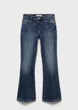 Pantalón de jean azul oscuro, tiro bajo, corte flare y cinco bolsillos.