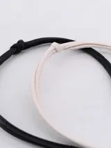 Set de dos tiaras para el pelo, una negra y otra blanca, forradas en cuero sintético.