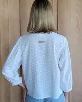 Camisa de mangas largas abullonadas con puños elásticos, cuello redondo y cierre frontal con botones.