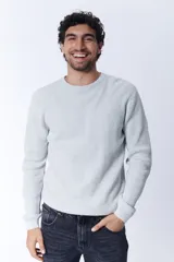 Buzo de tejido de punto con textura de gofre o waffle, color gris melange claro, de cuello redondo y manga larga.