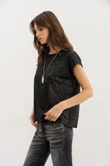 Remera negra de lentejuelas con calce relajado y cuello redondo.