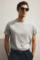 Remera gris de corte ajustado, cuello redondo y manga corta.