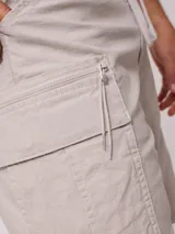 Bermuda cargo color beige, confeccionada en 98% algodón y 2% elastano, con cintura elástica ajustable con cordón y múltiples bolsillos.