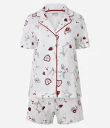 Conjunto de pijama americano corto confeccionado en algodón, compuesto por una camisa de manga corta con cuello solapa y abotonado delantero, y un short con cintura elástica y lazo. Estampado de íconos girlies como lacitos y frutillas.