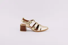 Sandalias doradas de cuero con punta cerrada, tiras entrecruzadas y hebilla lateral. Taco de madera de 6,5 cm.