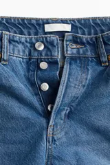 Pantalón de jean azul de corte recto, con tiro alto, cinco bolsillos y cierre con botones.