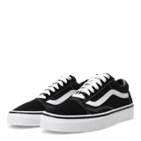 Championes Vans Old Skool negros con la clásica banda lateral blanca, confeccionados en lona y gamuza, con suela de goma blanca tipo waffle.