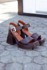 Sandalias de cuero color chocolate con plataforma y tacón cuadrado. Tira ancha sobre los dedos y tira con hebilla al tobillo.