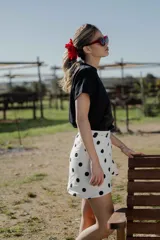 Minifalda pareo blanca con estampado de lunares negros y lazo lateral.