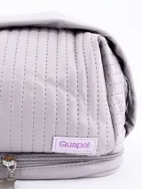 Neceser color crema con diseño acolchado y cierre doble.