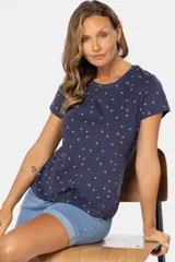 Remera de manga corta color gris claro con estampado de pequeñas figuras geométricas en azul.