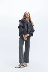 Campera de jean gris oscuro con volados en el frente y las mangas, cierre con botones metálicos.