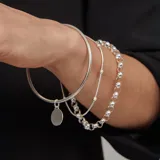 Pulsera rígida de plata 925 con dije circular grabado.