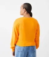 Sweater naranja de algodón, con cuello redondo, mangas largas y ribete elástico en la cintura.