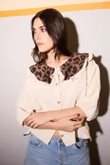 Camisa color beige con textura de hojas y cuello bebé removible con estampado animal print.