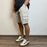 Bermuda cargo color beige de gabardina, con bolsillos laterales con solapa y bolsillos traseros.