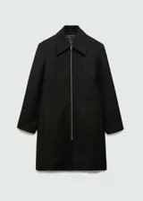 Abrigo negro de corte recto con cierre frontal con cremallera, cuello camisero y dos bolsillos laterales.