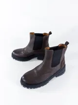 Bota de cuero color chocolate con elásticos laterales, ideal para fácil acceso y comodidad.