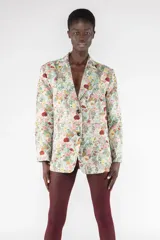 Blazer de corte clásico con estampado floral multicolor sobre fondo celeste. Tiene solapas y cierre con dos botones.