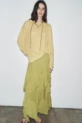 Falda midi color verde oliva, de tiro medio con cintura elástica y volantes asimétricos.