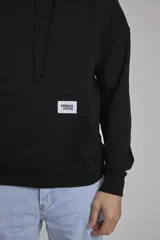 Buzo negro con capucha y bolsillo tipo canguro.